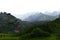 Hiking in ThorsmÃ¶rk - mountain panorama with two hikers and a hut with icelandic flag, Iceland