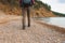 Hiking tourism adventure. Unrecognizable hiker girl tourist with backpack walking near lake. Backpacker woman feet and