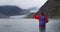 Hiking tourist on Alaska travel taking photo of glacier