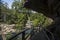 Hiking trail boardwalk under rocky overhang