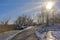 Hiking trail thruogh a snow landscape under a blue sky with pale winter sun