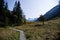 Hiking trail on wooden walkways with a view of the snow-capped peaks of the Alps