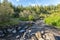 Hiking trial crosses Stadara water stream in Hallormsstadaskogur National forest in Eastern Iceland