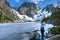 Hiking in Washington State. Woman standing by beautiful lake covered with ice.