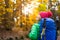 Hiking woman with backpack looking at inspirational autumn golden woods