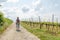 Hiking Woman with brown hair, straw hat and backpack hiking next to a wine field