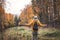 Hiking woman enjoying fresh air and feeling positive energy in autumn forest