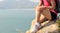 Hiking woman sit seaside rock