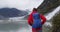 Hiking woman wearing backpack on hike in Alaska by glacier landscape