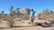 Hiking Women In The Mojave Desert, Among The Cacti, Joshua Trees And Stones
