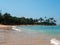 Hikkaduwa, Sri Lanka - March 8, 2022: Beautiful view of Hikkaduwa beach with green palm trees against the blue sky. People relax,