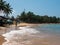 Hikkaduwa, Sri Lanka - March 8, 2022: Beautiful view of Hikkaduwa beach with green palm trees against the blue sky. People walk on