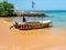 Hikkaduwa, Sri Lanka - March 8, 2022: Sri Lankan near the boat on the beach waiting for tourists to ride on the Indian Ocean