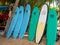 Hikkaduwa, Sri Lanka - March 8, 2022: Surfboards stand in a row along green palm trees