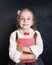 Ð¡hild girl in school uniform clothes with book on chalk board