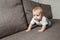 Hildhood babyhood and people concept happy smiling little baby boy or girl crawling on sofa