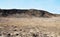 Hill on the dry flat desert-like landscape
