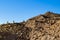 Hill of earth and rock fragments against a clear blue sky