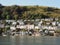 A hill in Kingswear , Devon seen across the River Dart in sunshine showing neat and colourful houses