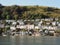 a hill in Kingswear , Devon seen across the River Dart in sunshine showing neat and colourful houses