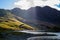 Hill and mountain in Snowdonia National Park with a lake and sunrays crossing the clouds