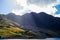 Hill and mountain in Snowdonia National Park with a lake and sunrays crossing the clouds