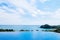 Hill top infinity edge pool with seascape and blue sky