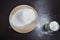 A hill of white flour and a glass on a wooden table