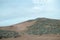 Hills of the desert covered with tillandsia plant under blue cloudy sky