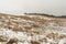 Hills with dry grass are covered with snow. Gloomy winter day. Nature background