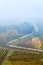 Hills with vineyards and the road disappearing into the fog . Countryside with vineyard and fields with patterns on hills. South