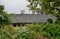 Hillside abandoned tile-roofed building in cloudy afternoon