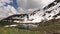 Hillside covered with snow. Vivid cumulus clouds quickly flying across blue sky