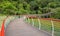 Hillside planked walkway with colorful steel railings in woods