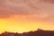 Hillside view of homes, ovservatory and palms silhoutted against lavender, pink, orange, and yellow