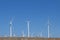 Hillside view wind farm bright white turbines blue sky