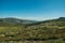 Hilly landscape covered by green fields and rocks