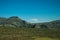 Hilly landscape covered by green fields and rocks