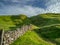 Hilly landscape in the Peak District in the UK with a stone fence