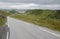 Hilly lanscape with tarmac road and grassy bogs, Norway