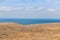 Hilly seashore and a blue surface of the sea.