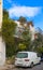 Hilly side street in Thiseio district of Athens Greece near Acropolis with flowering vines growing up walls and orange trees along