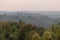 Hilly terrain with layers of forest in the mist at dusk in early autumn