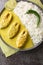 Hilsa fish cooked with mustard and traditional Bangladeshi spices served with white rice closeup on the plate. Vertical top view