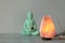 Himalayan salt lamp, buddha figure, incense and crystals on stone table near grey wall, space for text