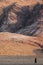 Himba woman walking in an arid landscape.