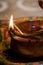 Hindu decorated clay lamp with fire on a blurry background. Hindu ritual and cultural Diya for special occasions. Decorated Hindu