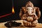 Hindu god Ganesh on a black background. Rudraksha statue and rosary on a wooden table with a red incense stick and incense smoke