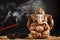 Hindu god Ganesh on a black background. Rudraksha statue and rosary on a wooden table with a red incense stick and incense smoke