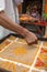 Hindu priest coloring traditional sand art Rangoli with religious pattern